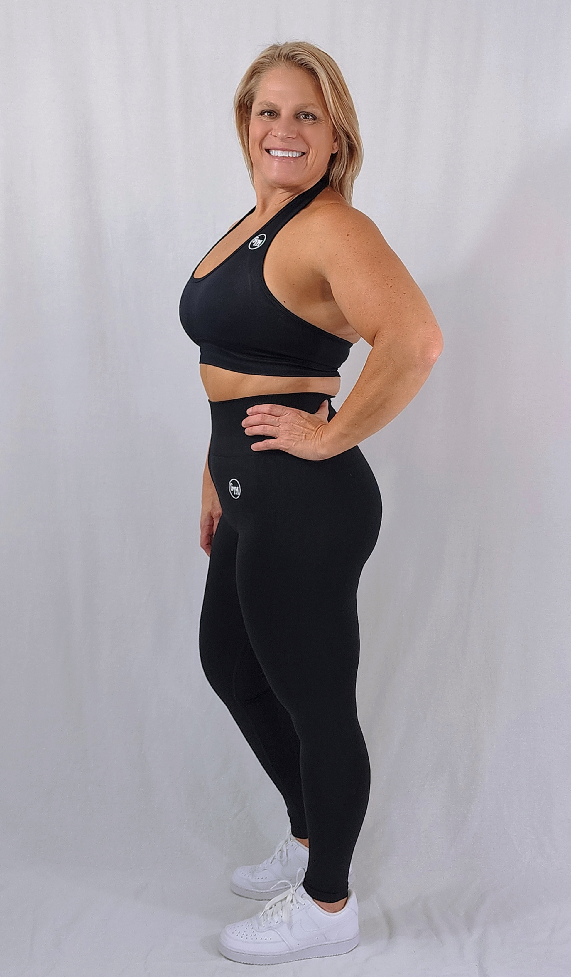 Gym Brand Apparel black leggings and black halter sports bra side view.