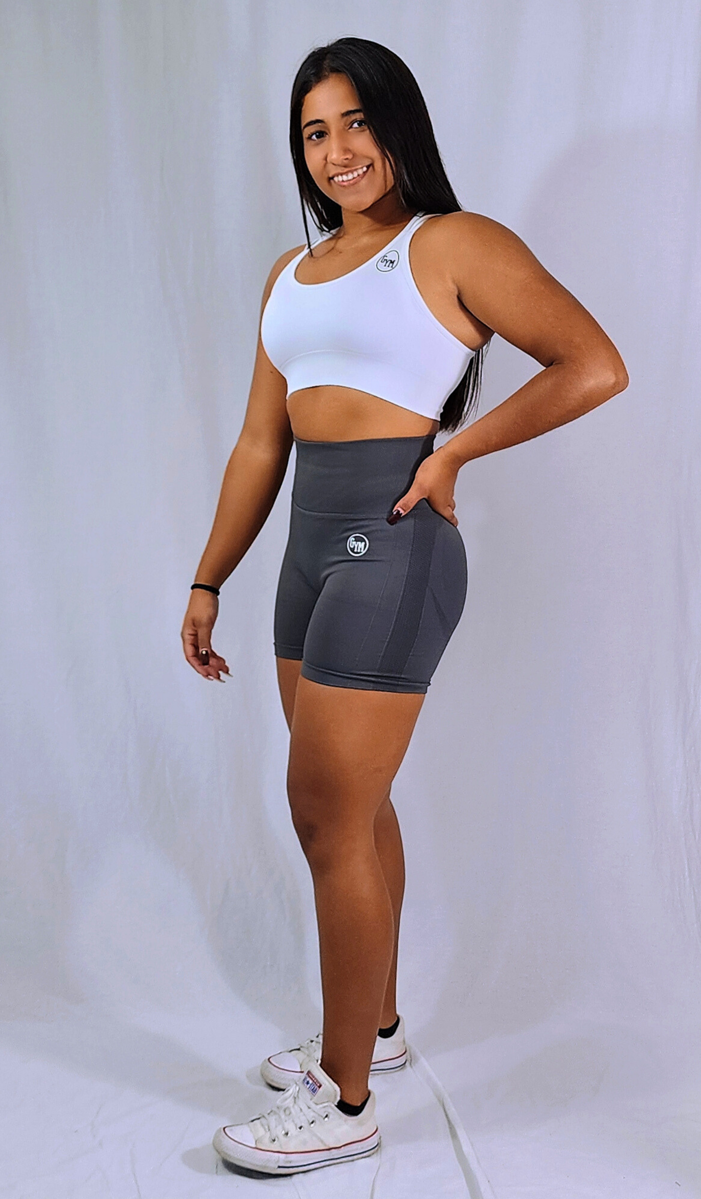 Gym Brand Apparel grey shorts and white strap back sports bra side view.