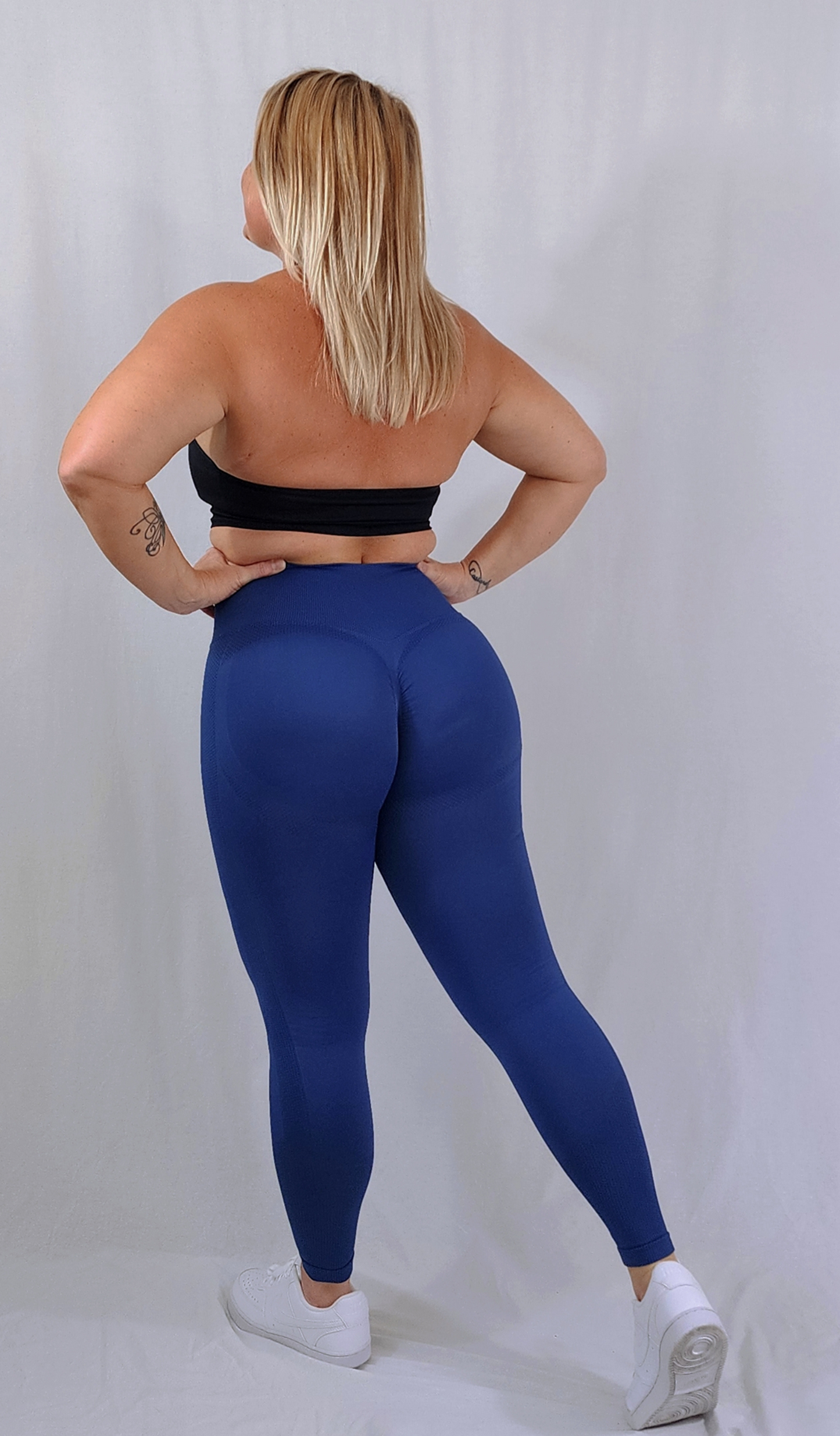 Gym Brand Apparel blue leggings and black halter sports bra back view.