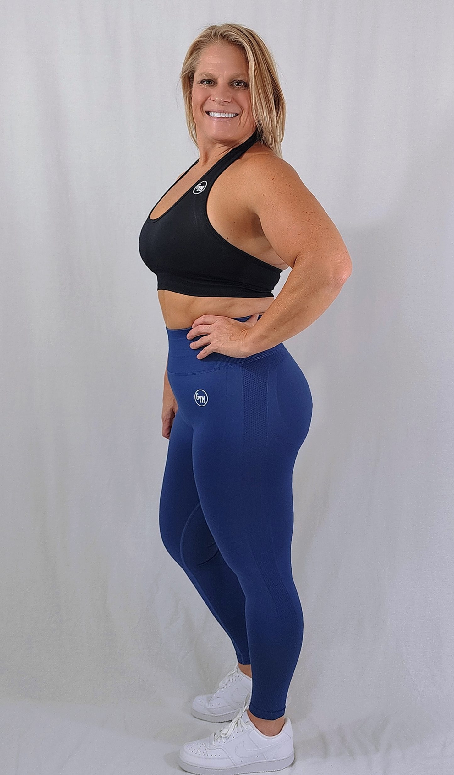 Gym Brand Apparel blue leggings and black halter sports bra side view.