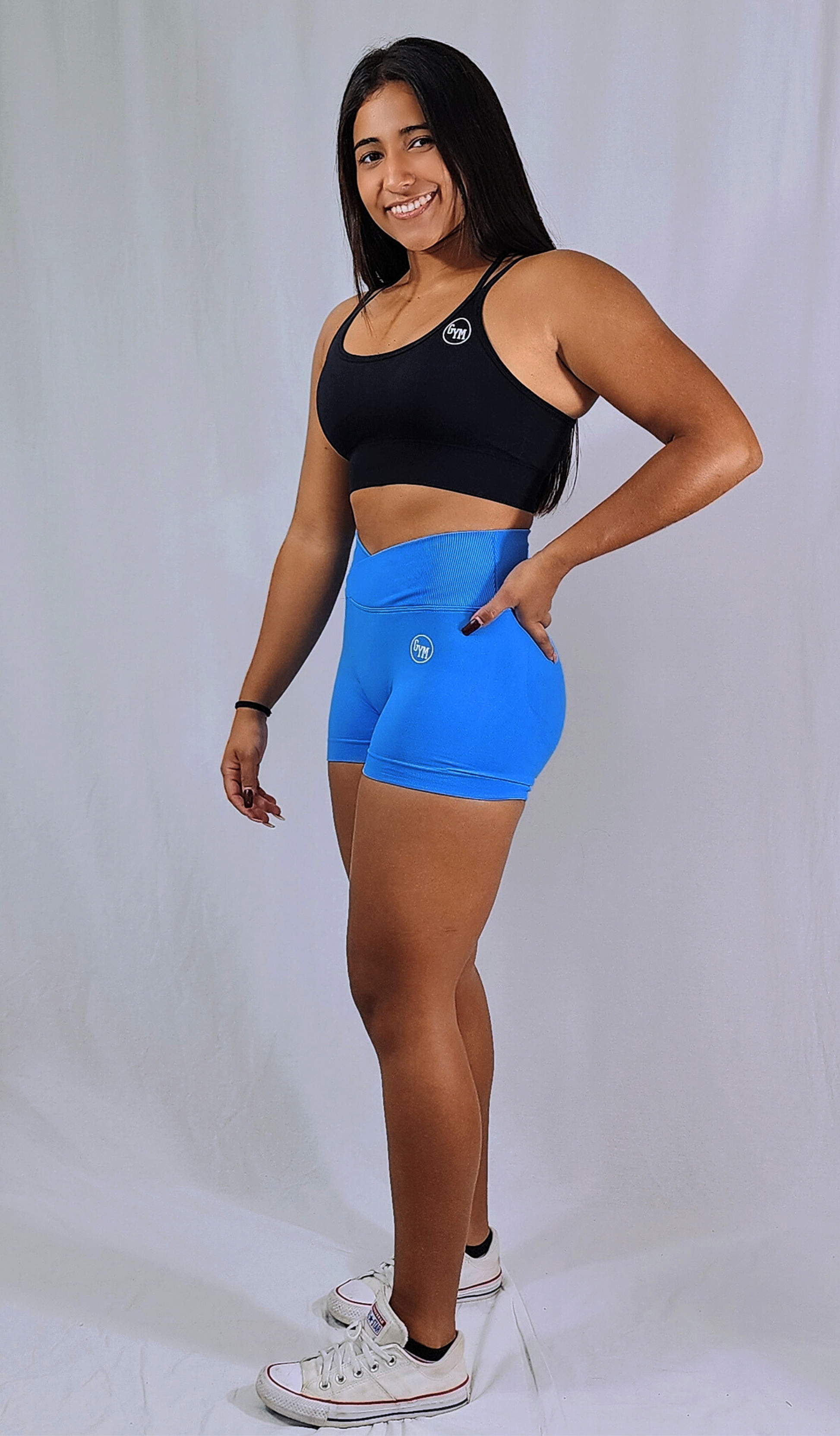 Gym Brand Apparel blue shorts and black strap back sports bra side view.