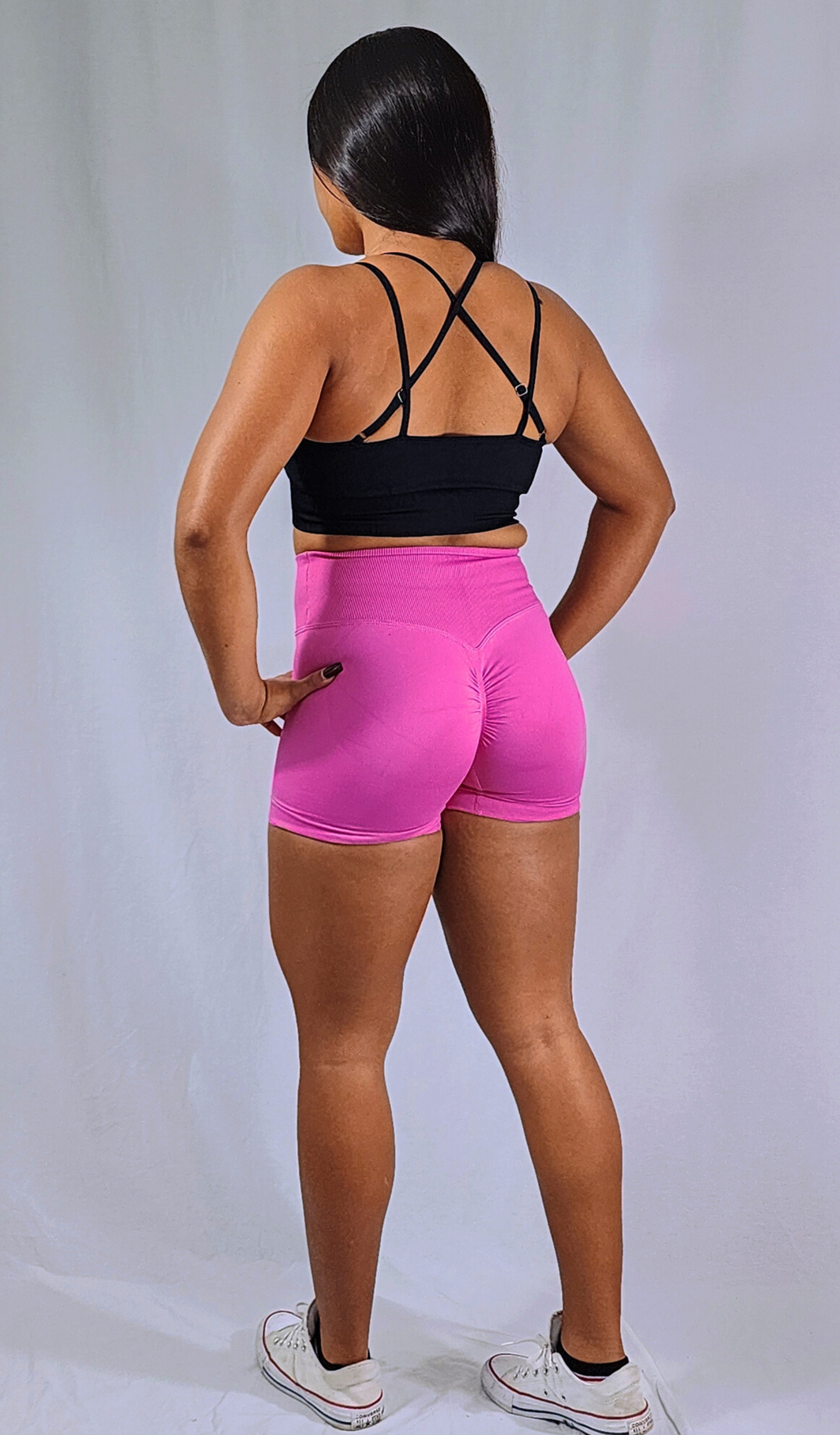 Gym Brand Apparel pink shorts and black strap back sports bra back view.
